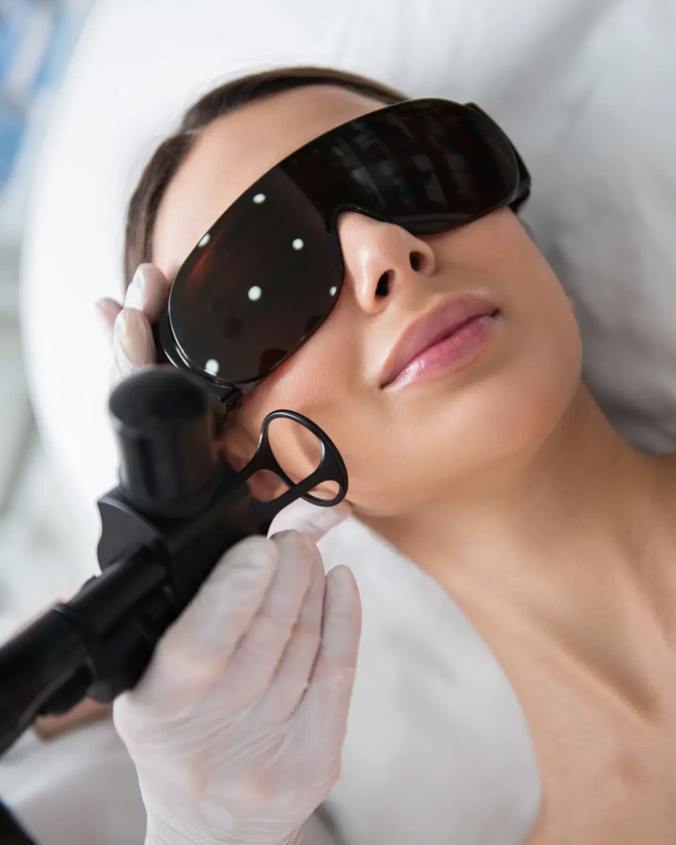 A professional technician at BodyBrite Cooper City performing a laser treatment on a client's face, ensuring safety and comfort.