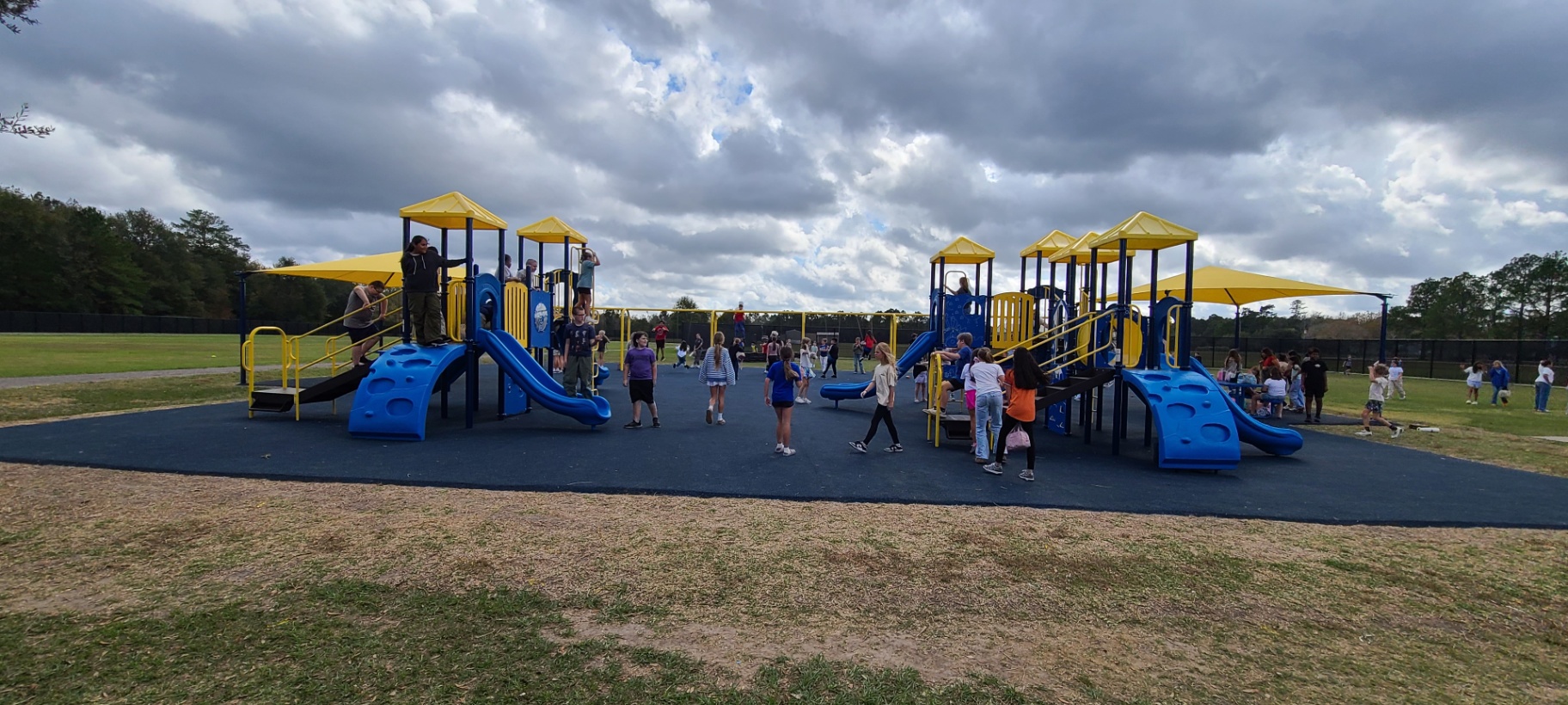 Large inclusive community playground with poured-in-place rubber surfacing and durable steel frames
