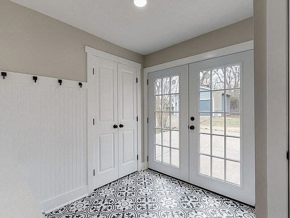 Recently remodeled entryway featuring double French doors and modern finishes