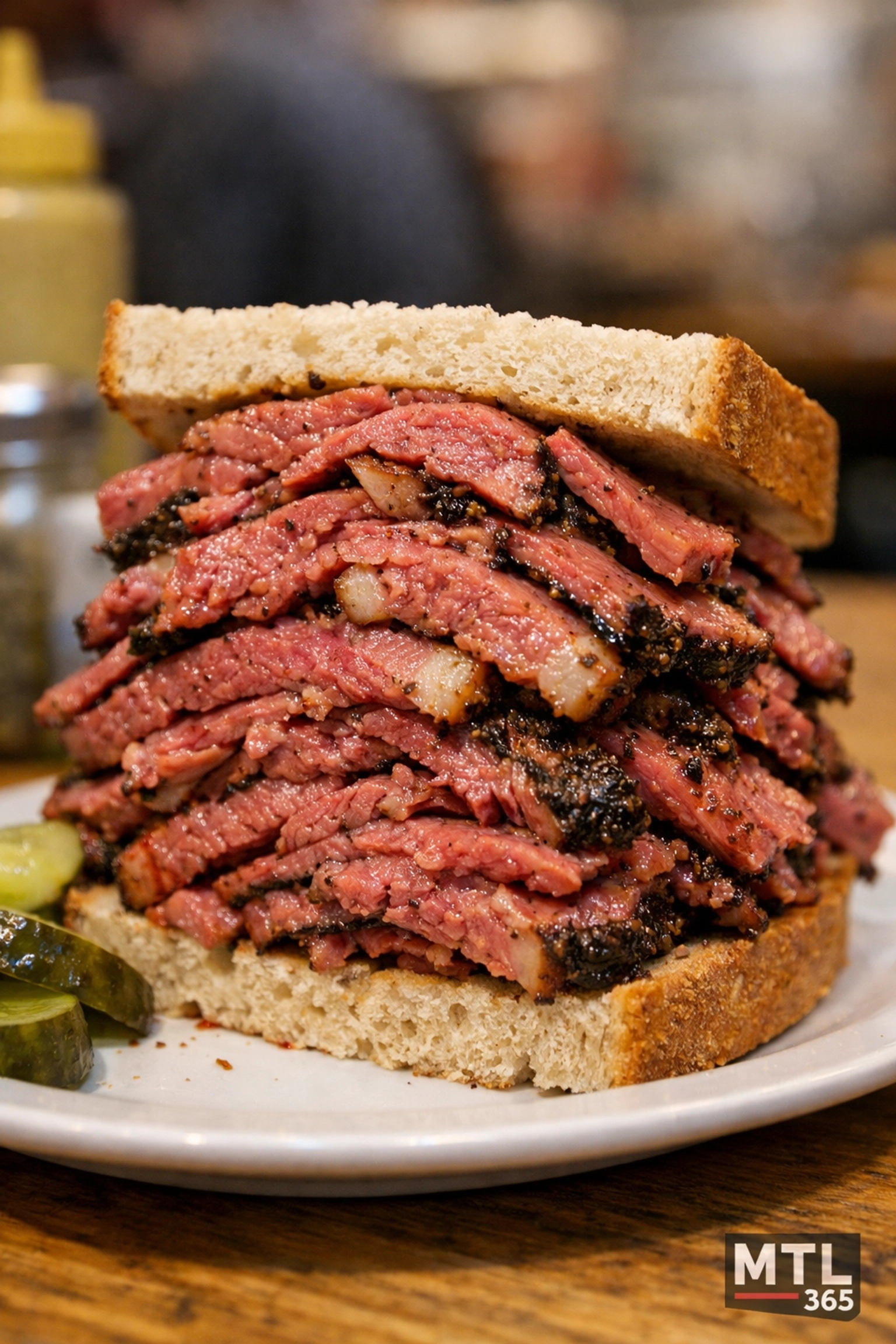 Authentic medium-cut Montreal smoked meat sandwich with spices and fat on rye bread.