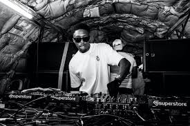 A DJ wearing sunglasses operates a professional soundboard at an event, showcasing special FX and event entertainment rental services.