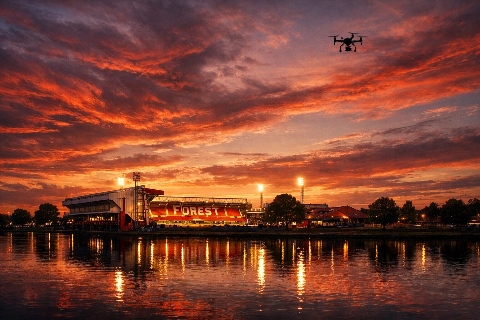 Drone performing an aerial ash scattering tribute over Nottingham Forest's City Ground at twilight.