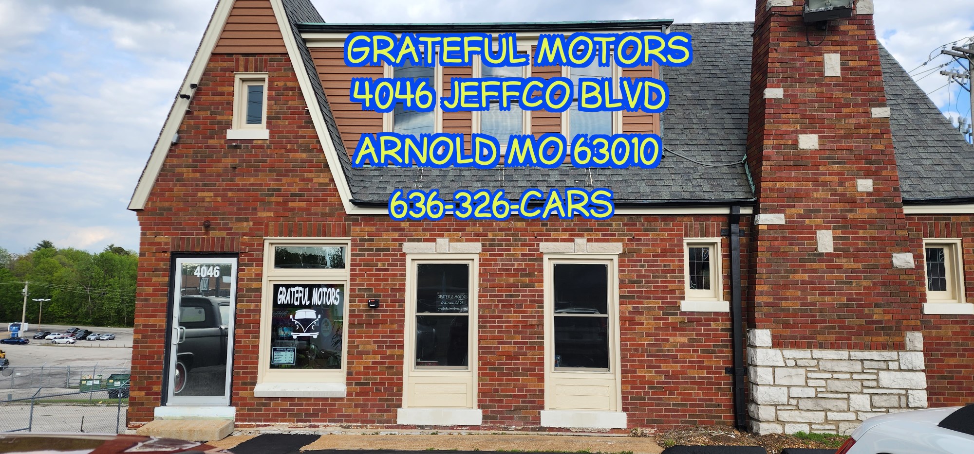 Front view of the Grateful Motors dealership office, located in a brick building at 4046 Jeffco Blvd