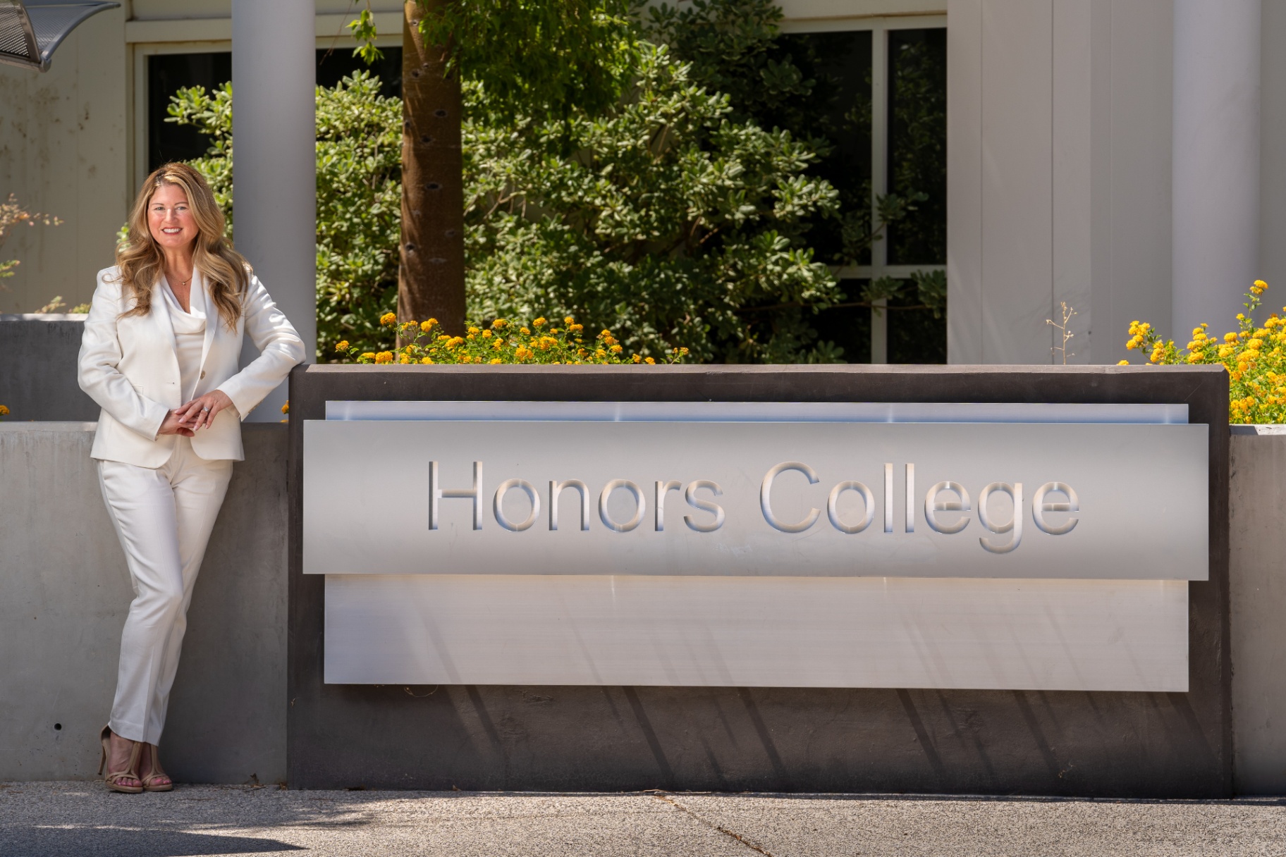 Professional corporate portrait of a woman in a white suit
