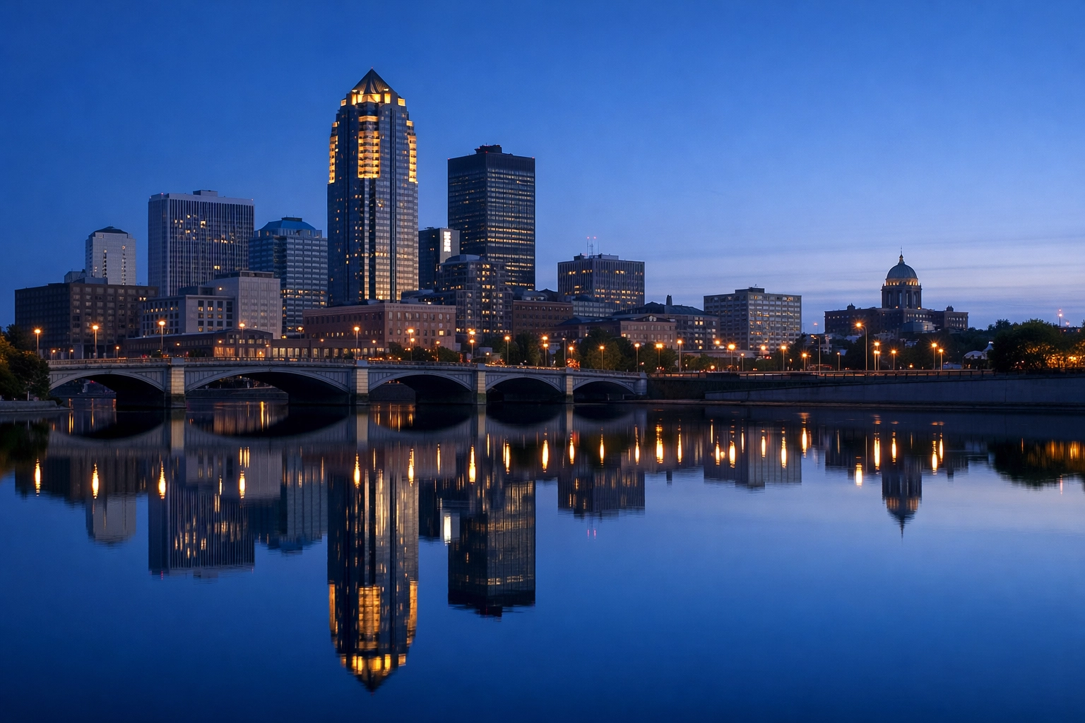 Des Moines skyline and 801 Grand building at sunrise reflecting on the river at UTC-6.