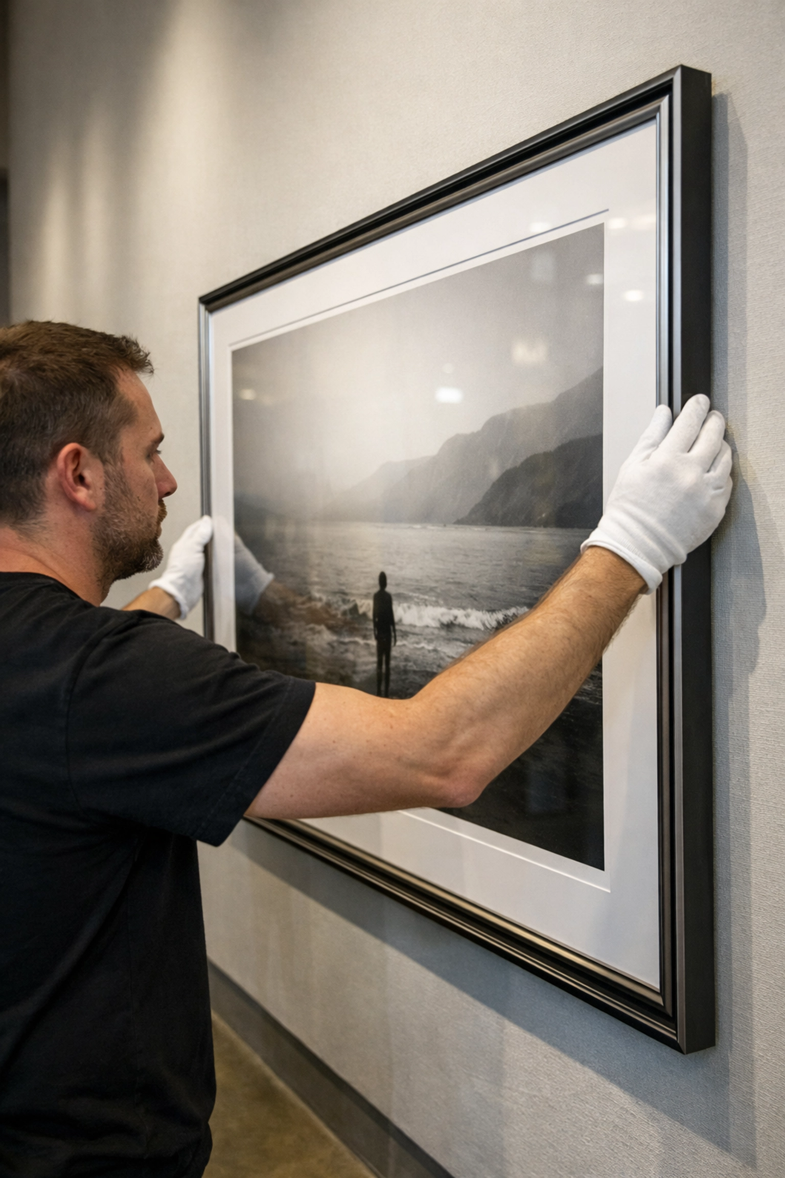 Art handler installing museum quality prints using white gloves to protect the fine art surface.