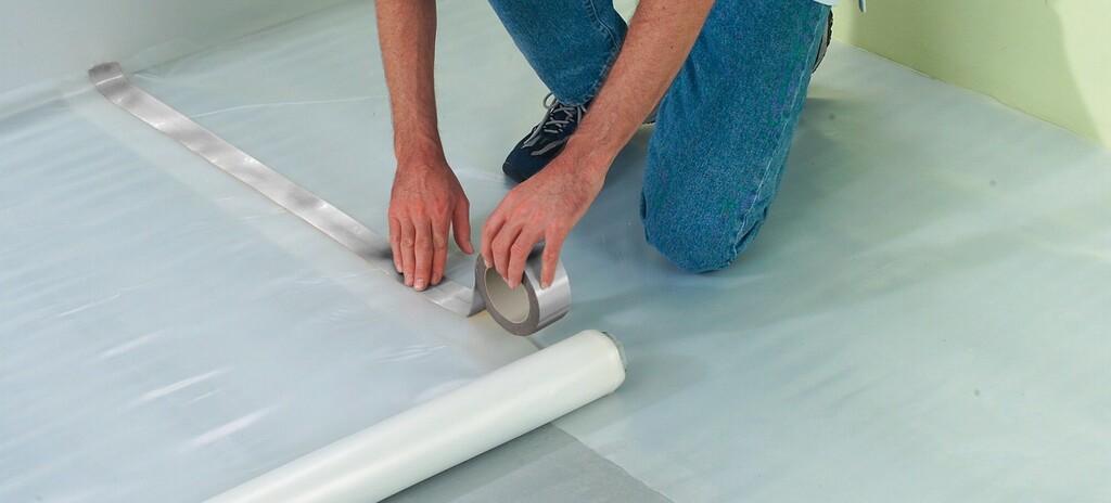Installer applying underlayment for hardwood flooring