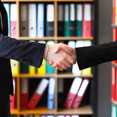 Two professionals shaking hands, representing the trust and successful partnership between Migrate2Australia and its clients.