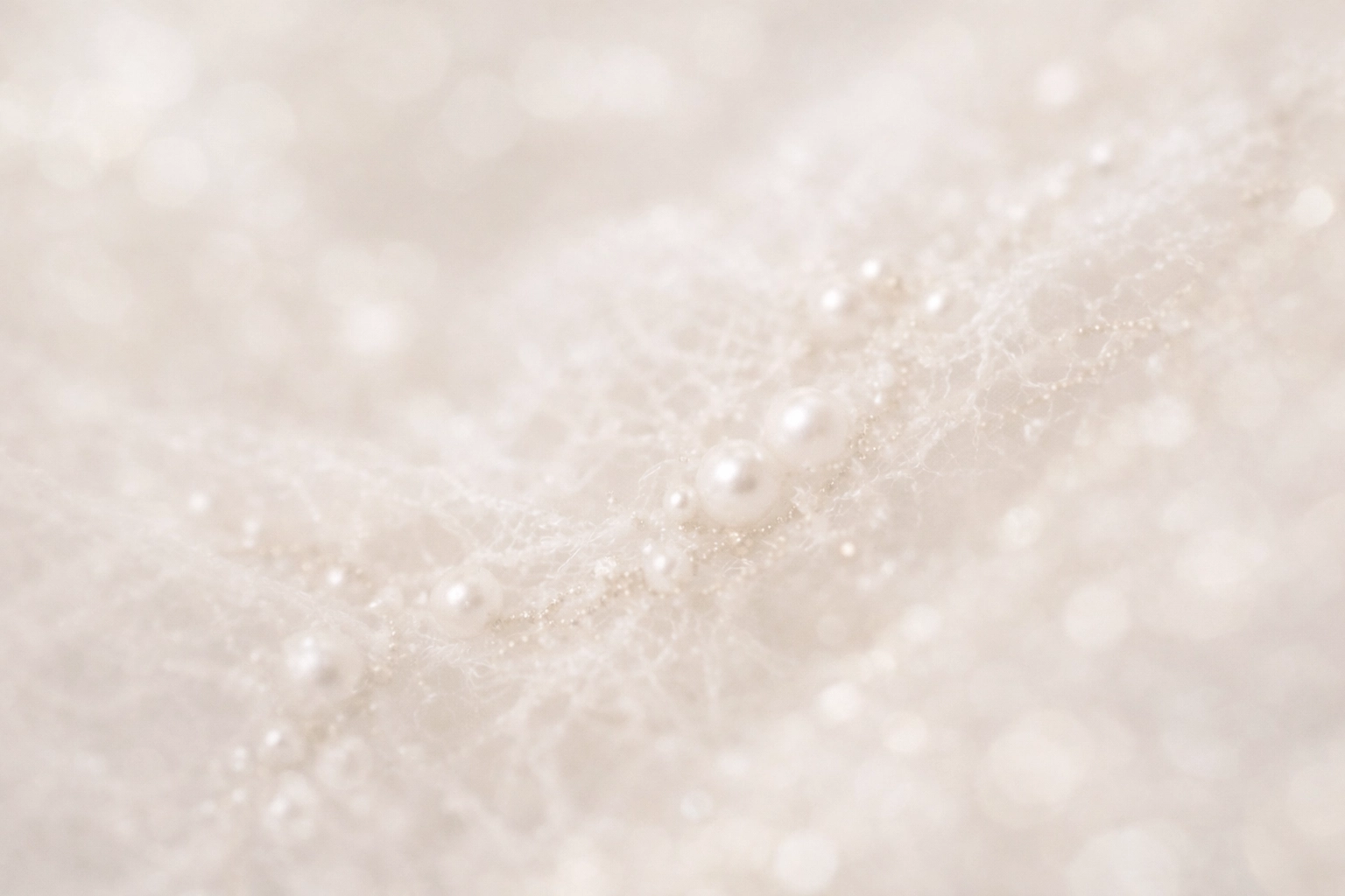 Detailed macro shot of luxury bridal lace and pearl beads on an ethereal wedding gown.