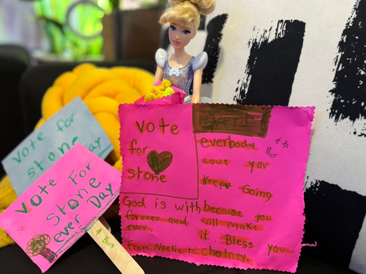 The actual photo of Noelie’s gift showing a Cinderella doll with handmade pink and blue signs and heartfelt messages.