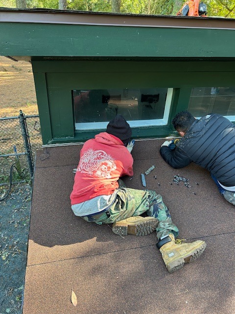 Our crew installing a self-adhesive modified bitumen system to match the existing shingle color on a low-slope residential section