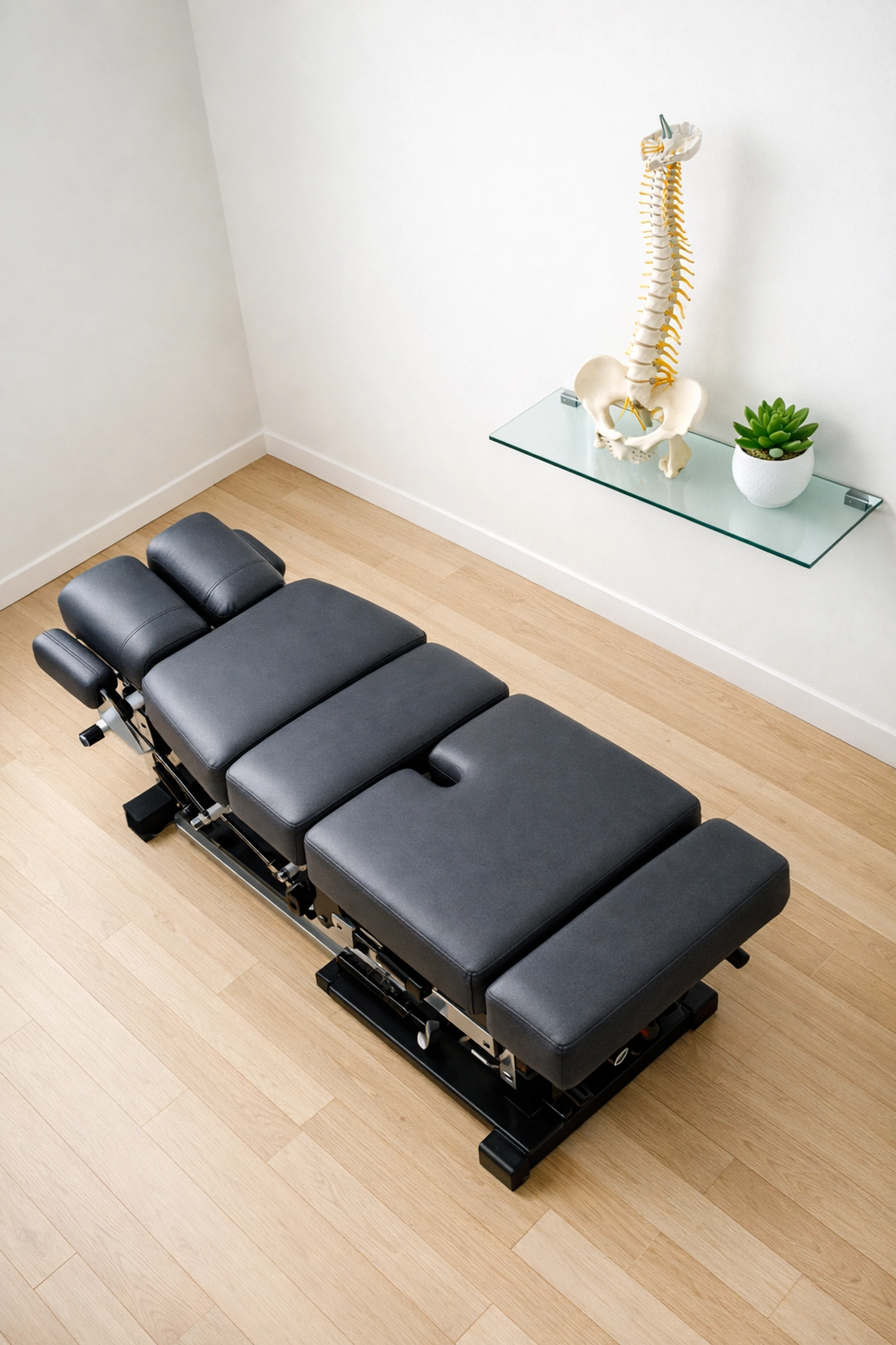 A clean, modern chiropractic adjustment room showcasing a professional healthcare environment.