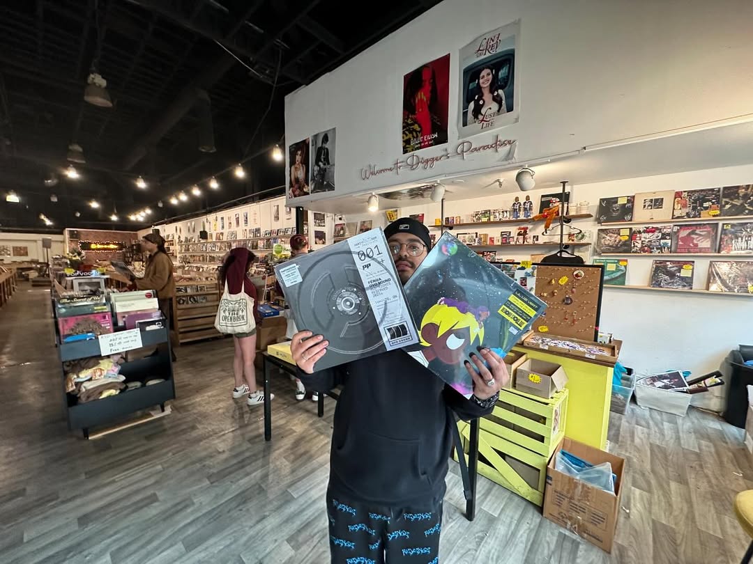 A customer at Nivessa holds up two vinyl records inside the music store