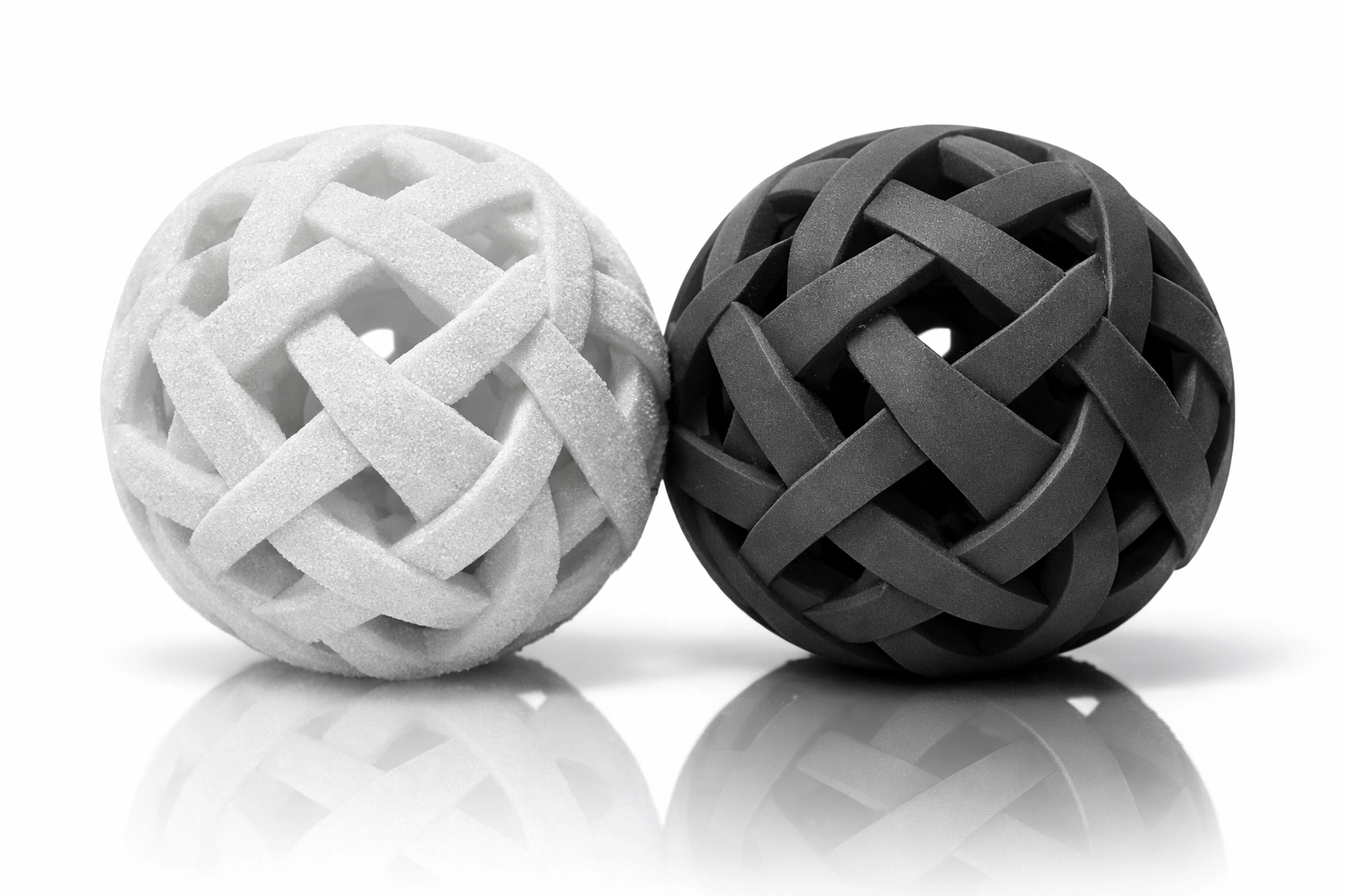 Visual comparison of white grainy SLS and smooth charcoal MJF surface finishes for 3D printed parts. Visual comparison of white grainy SLS and smooth charcoal MJF surface finishes for 3D printed parts.