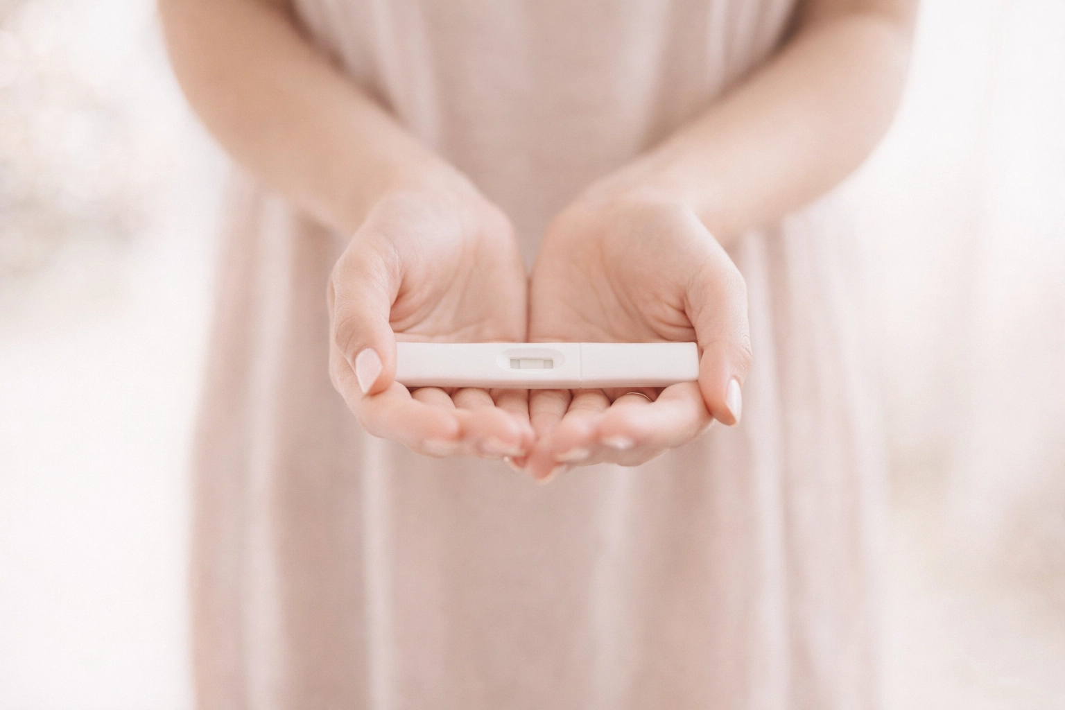 A hopeful couple embracing with joy next to baby booties, symbolizing New Direction Fertility's IVF sweepstakes. A joyful couple holding a positive pregnancy test, symbolizing the hope and excitement of the New Direction Fertility sweepstakes.