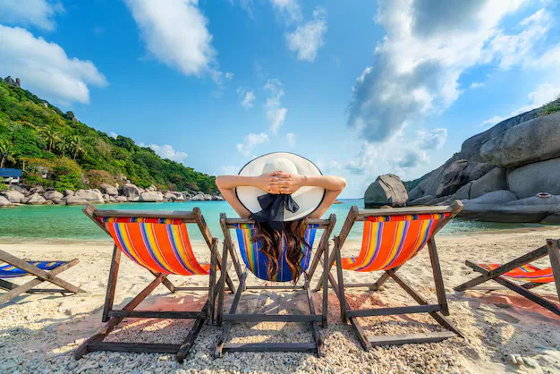 woman-relaxing-tropical-beach-sunhat-deck-chair.webp