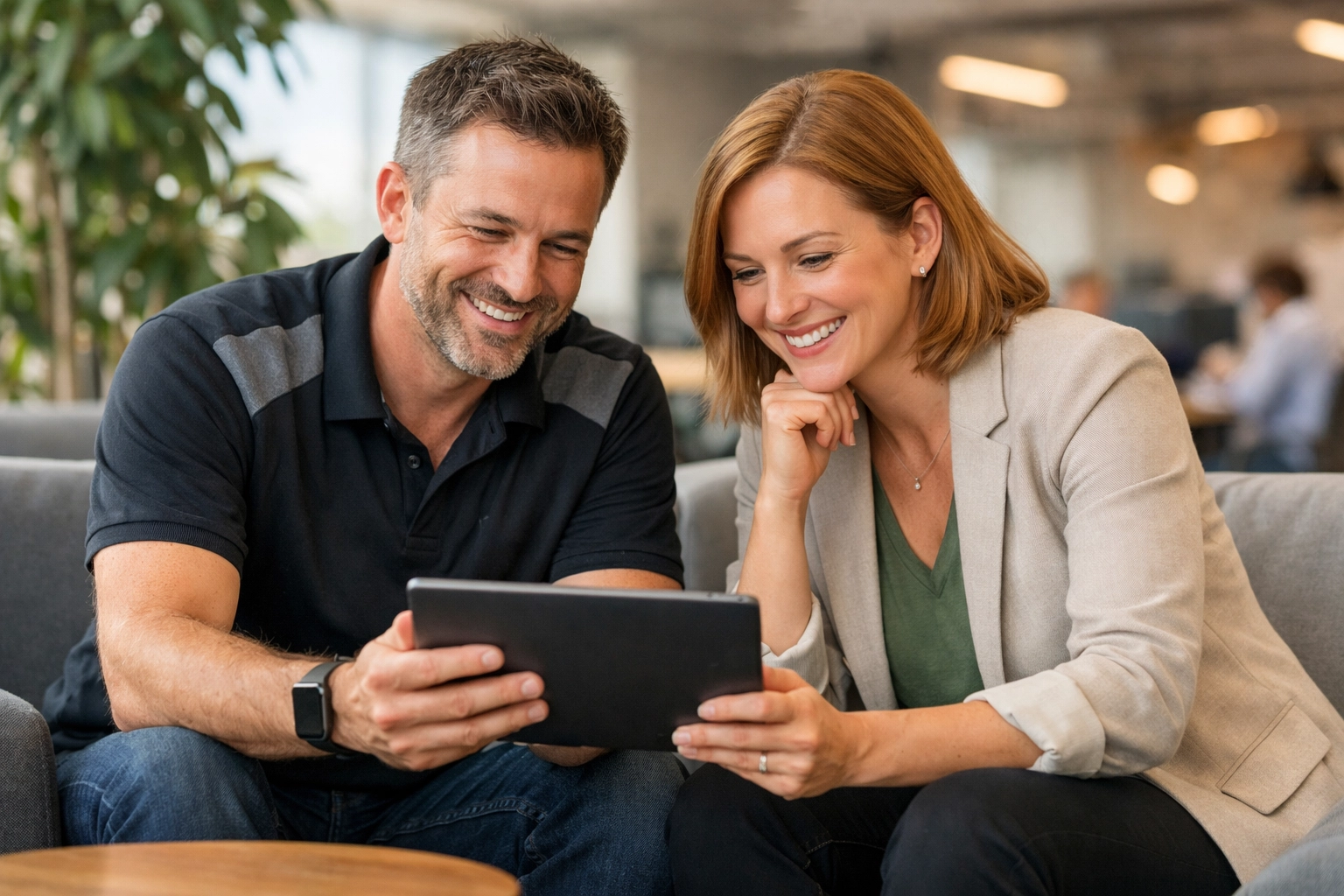 A ServiceNow implementation partner and project manager collaborating on a tablet in a modern, productive office.