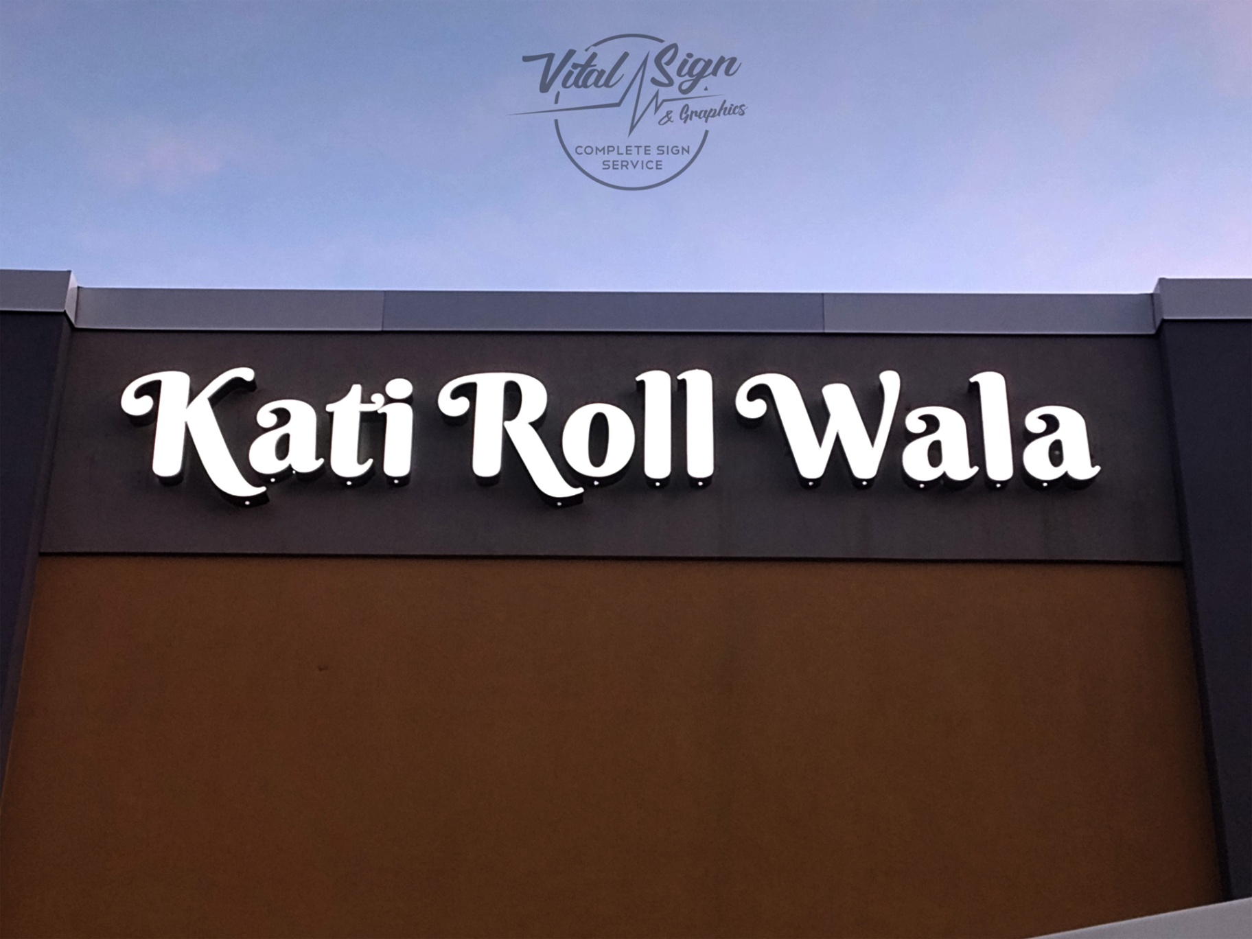 Kati Roll Wala Channel Letter Sign Custom exterior lighted channel letter sign for 'Kati Roll Wala,' installed on a commercial storefront. Bright white illumination ensures high visibility at night, with bold, rounded typeface for branding. Fabricated and mounted by Vital Sign & Graphics.