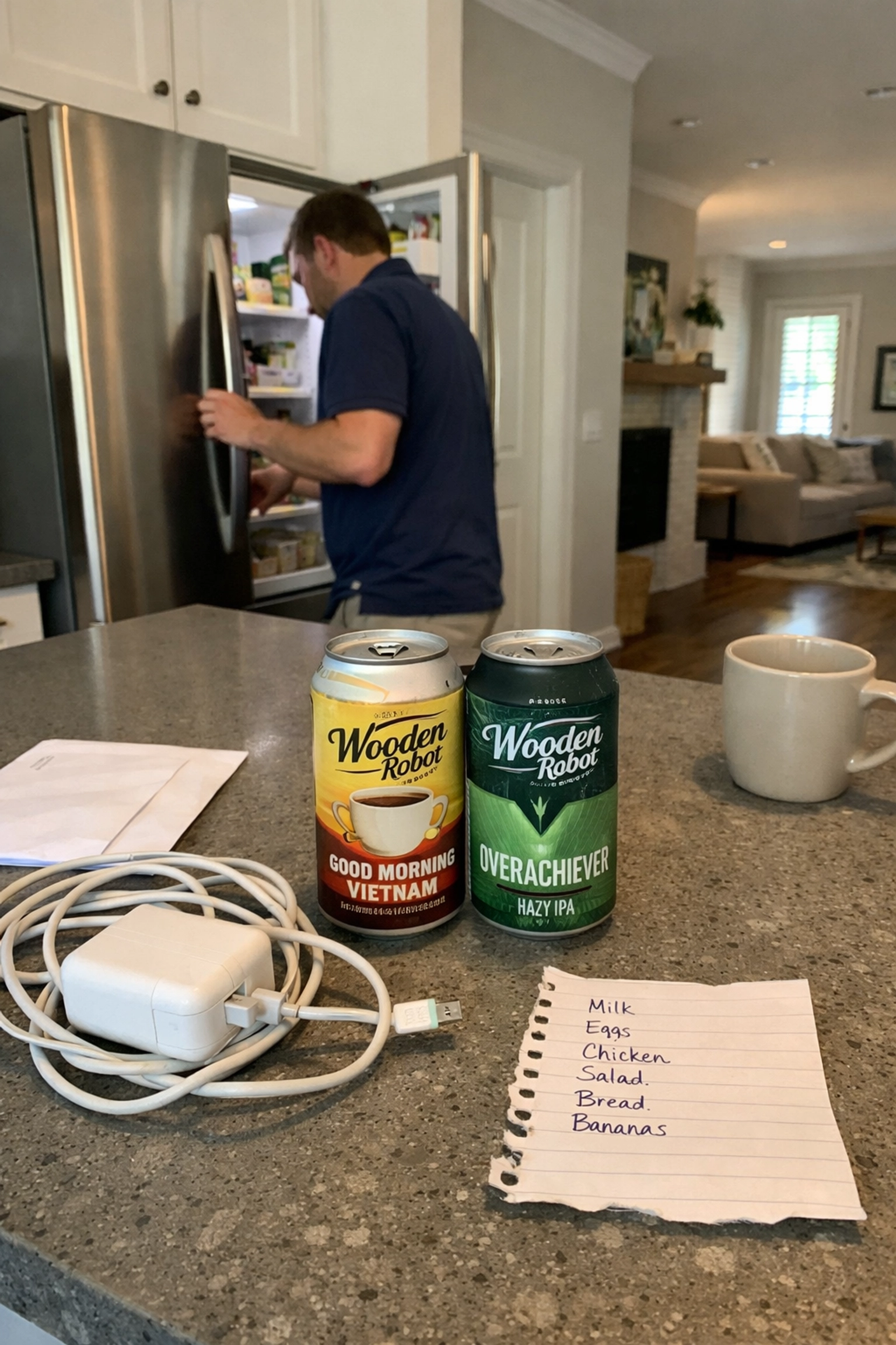 Professional resident in a modern Charlotte shared kitchen with local craft beer and laptop charger on the island counter.