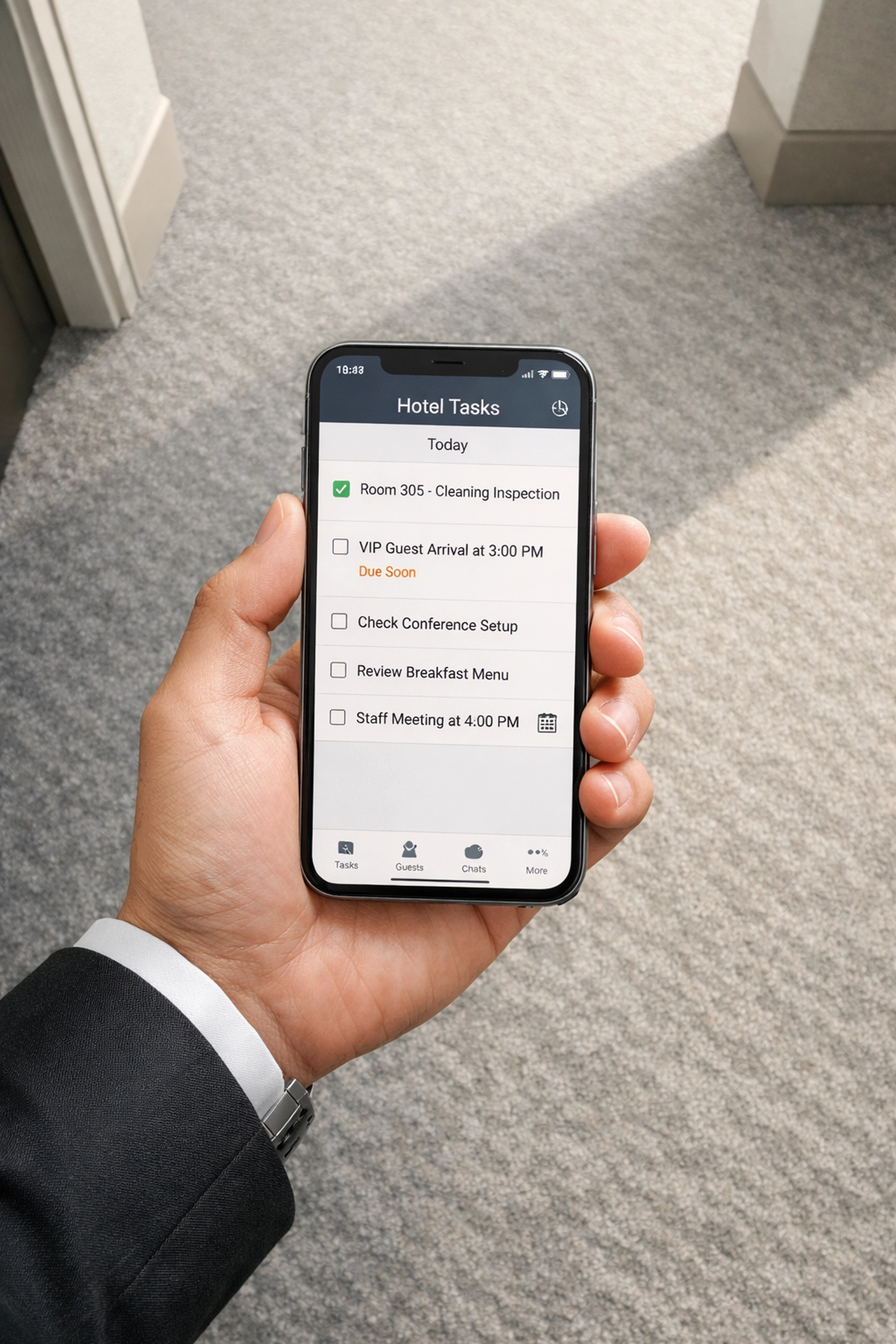 Smartphone displaying hotel management app for real-time task coordination