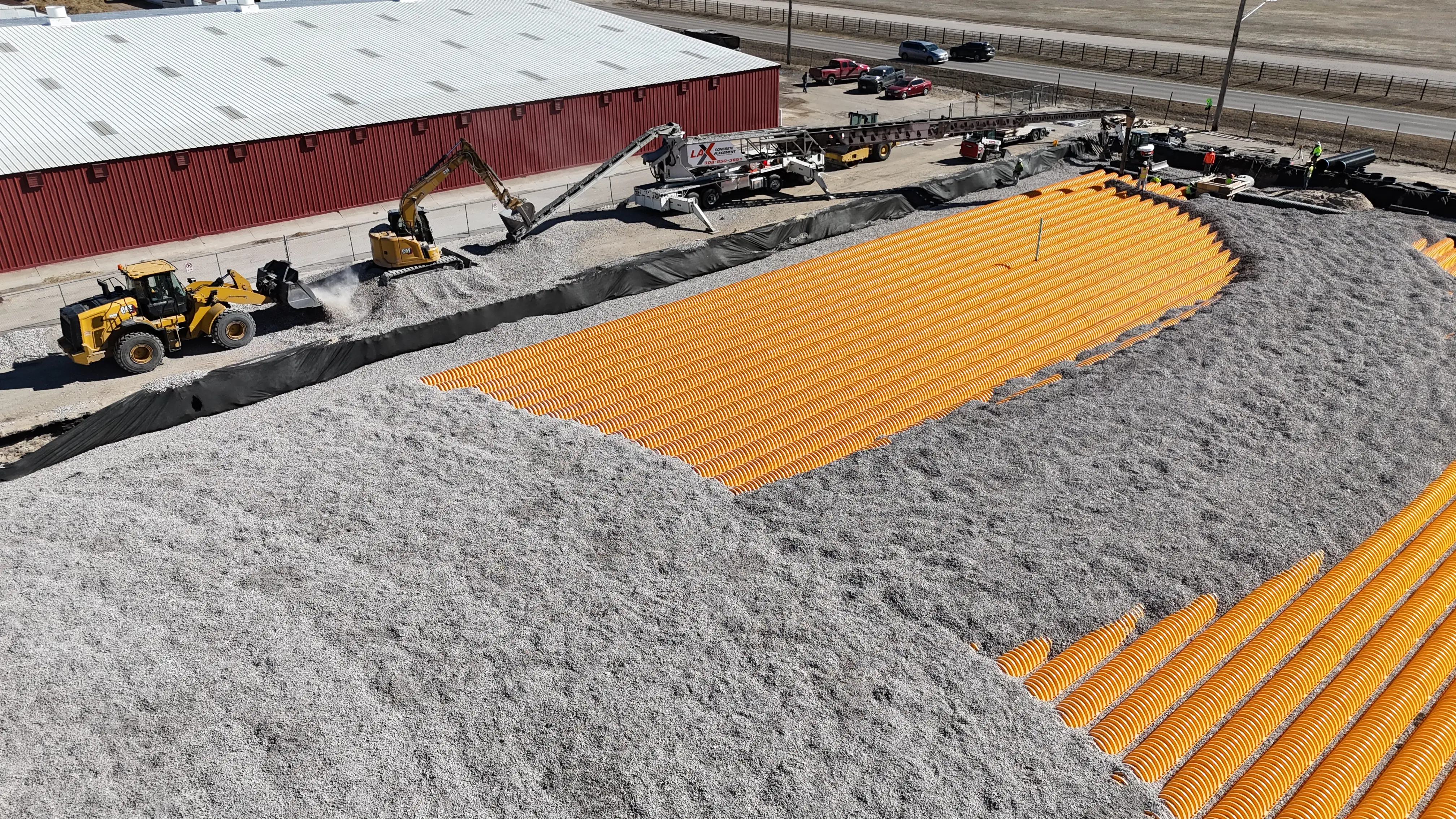 Telebelt conveyor truck delivering gravel to an Omaha construction site under low-clearance power lines.