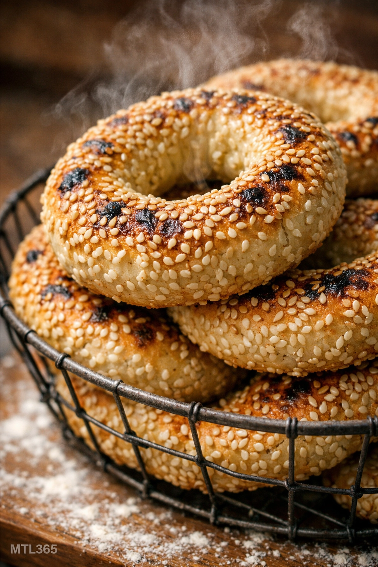 Freshly baked Montreal sesame bagels stacked in a basket at a local bakery.