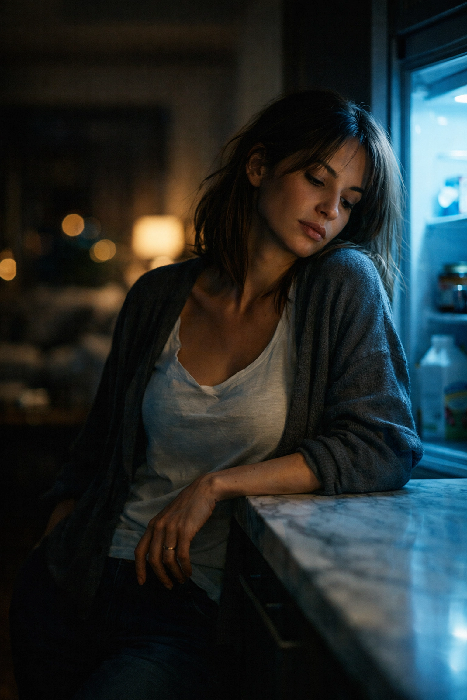 Sleep-deprived woman in a dark kitchen reflecting the impact of exhaustion on postpartum metabolism.