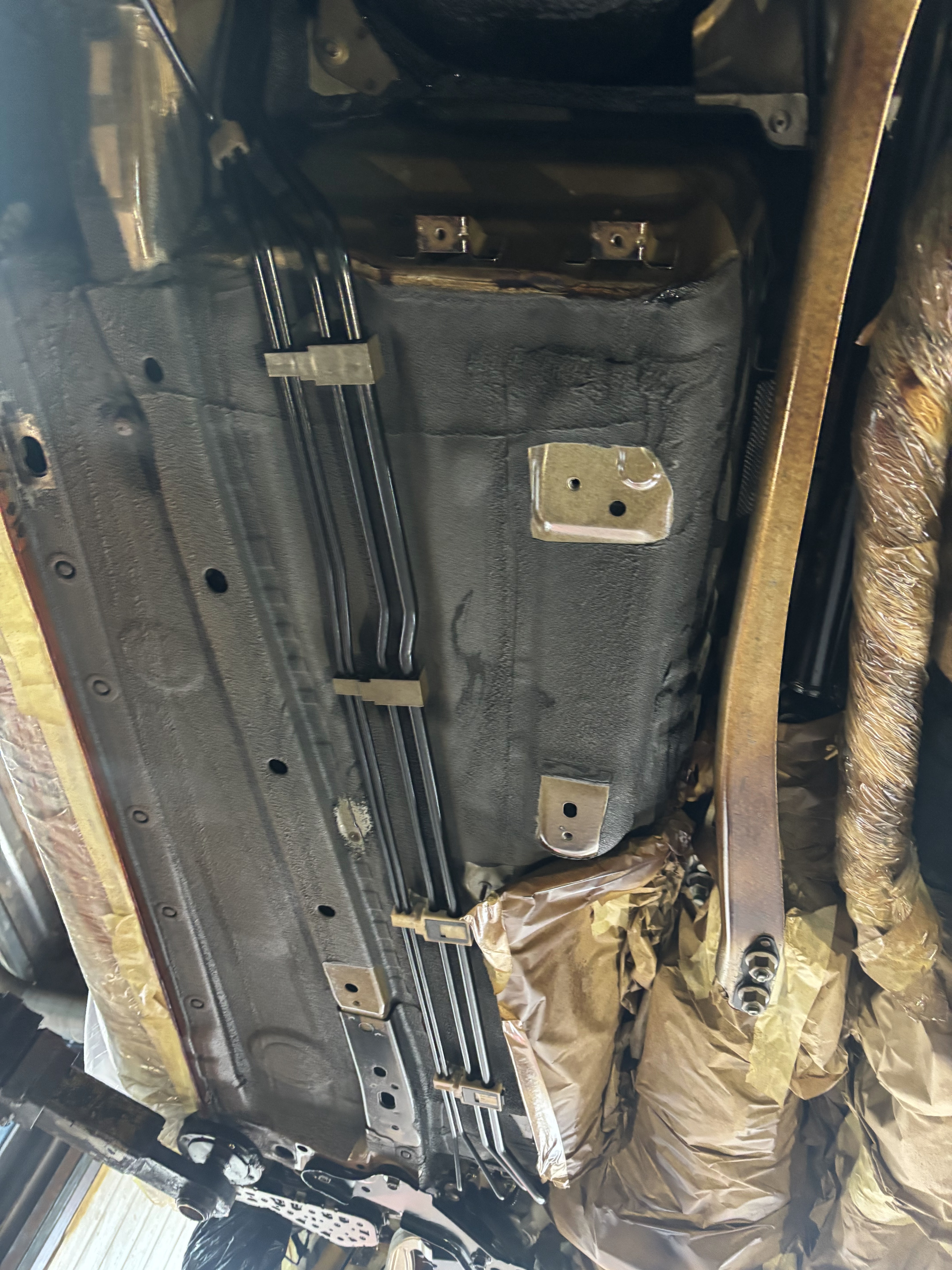 Vehicle underbody with freshly applied rust proofing treatment