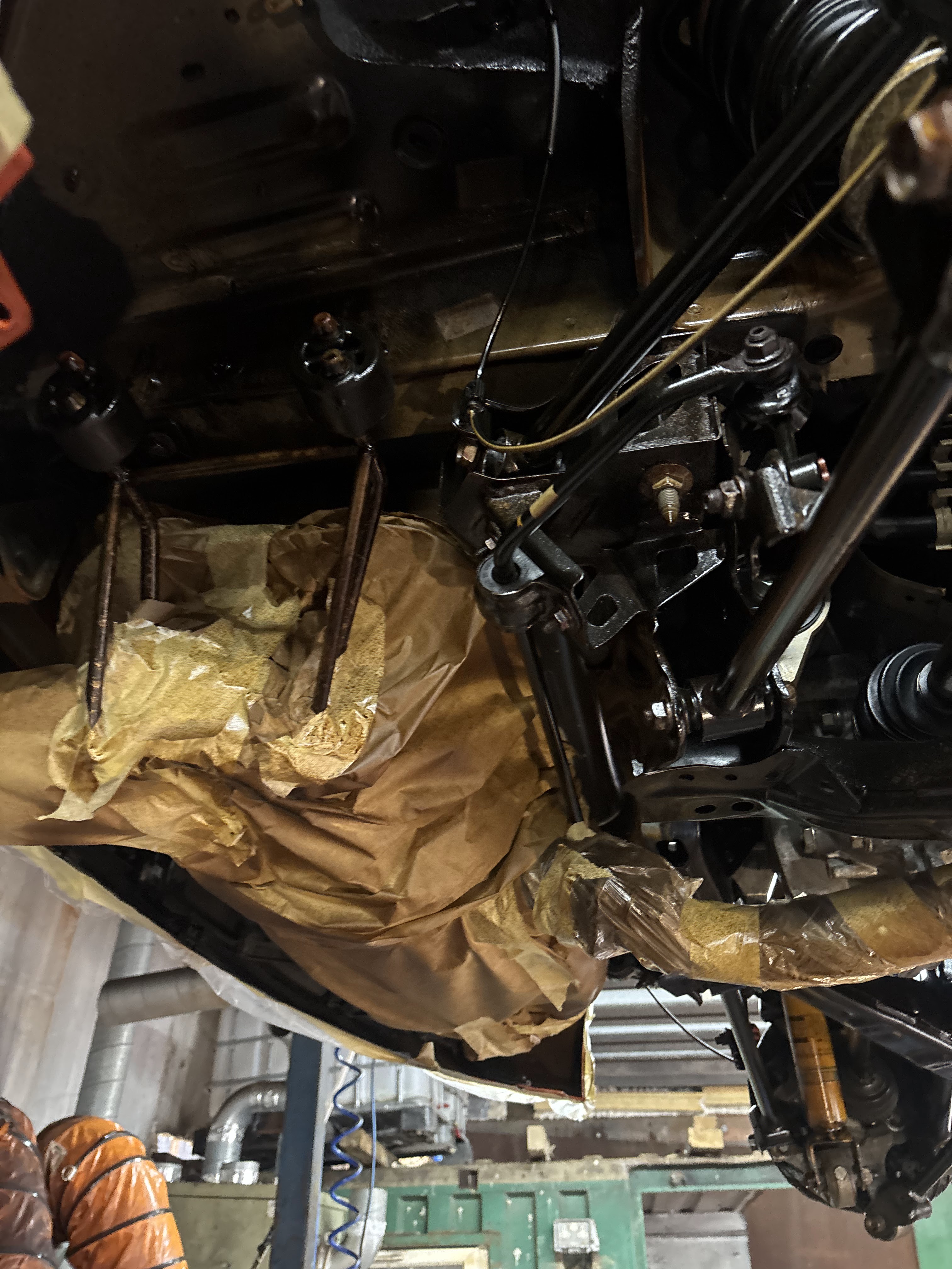 Vehicle underbody preparation in progress with masked components