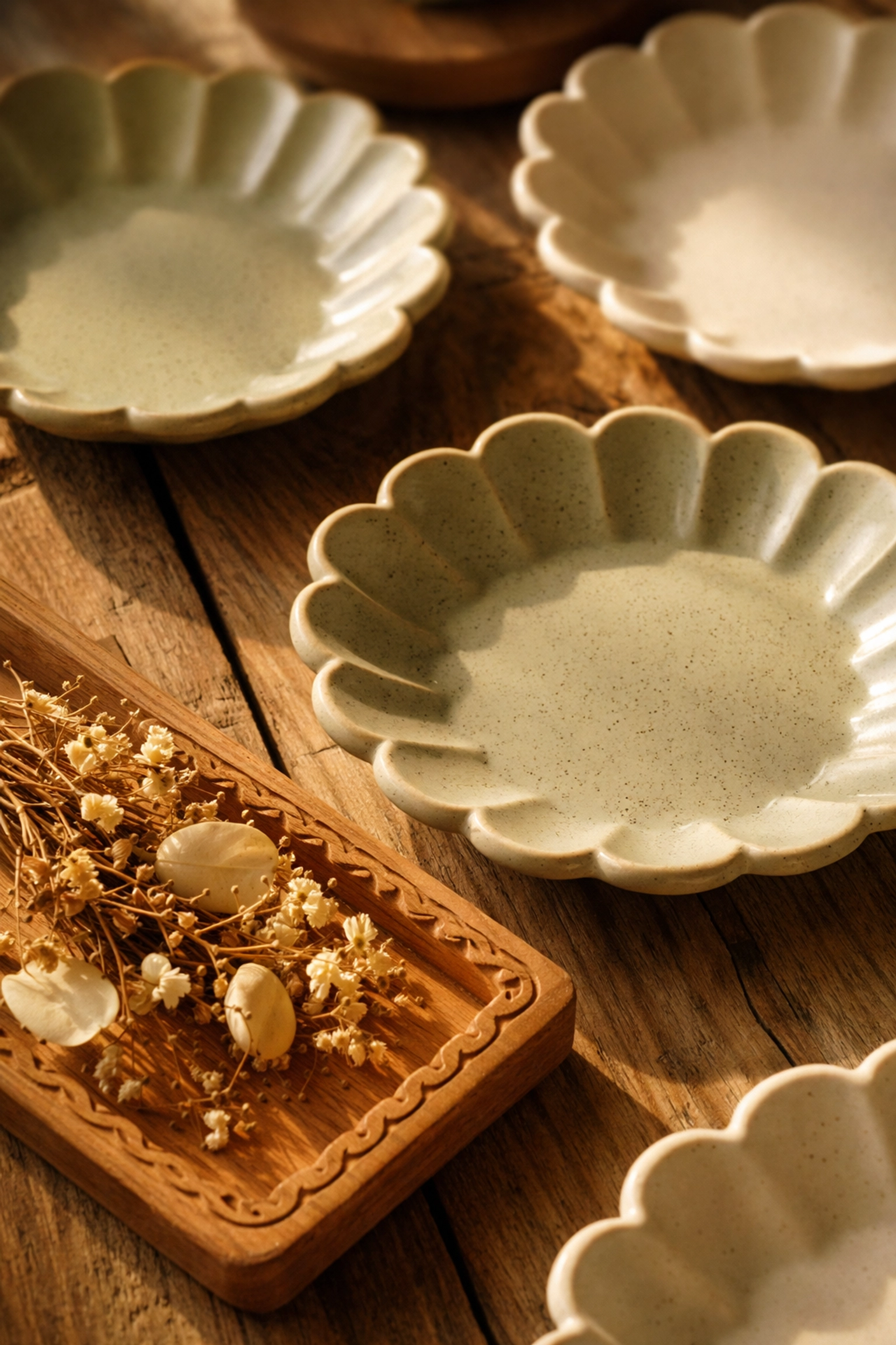 Scalloped-edge ceramic dishes and hand-finished wooden trays on rustic wood, showcasing handmade decor details