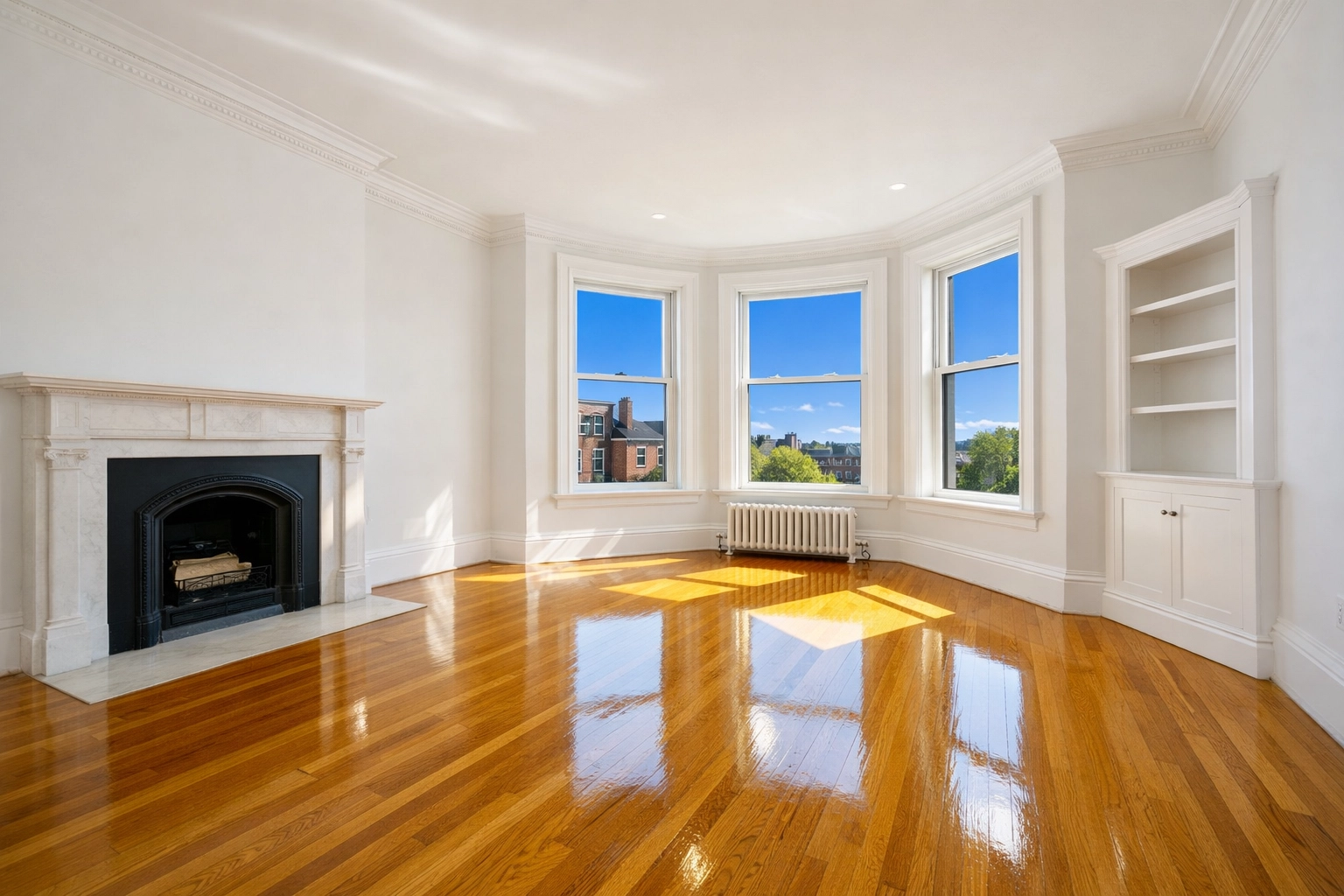 Pristine empty Boston apartment living room with polished hardwood floors after a professional move-in cleaning.