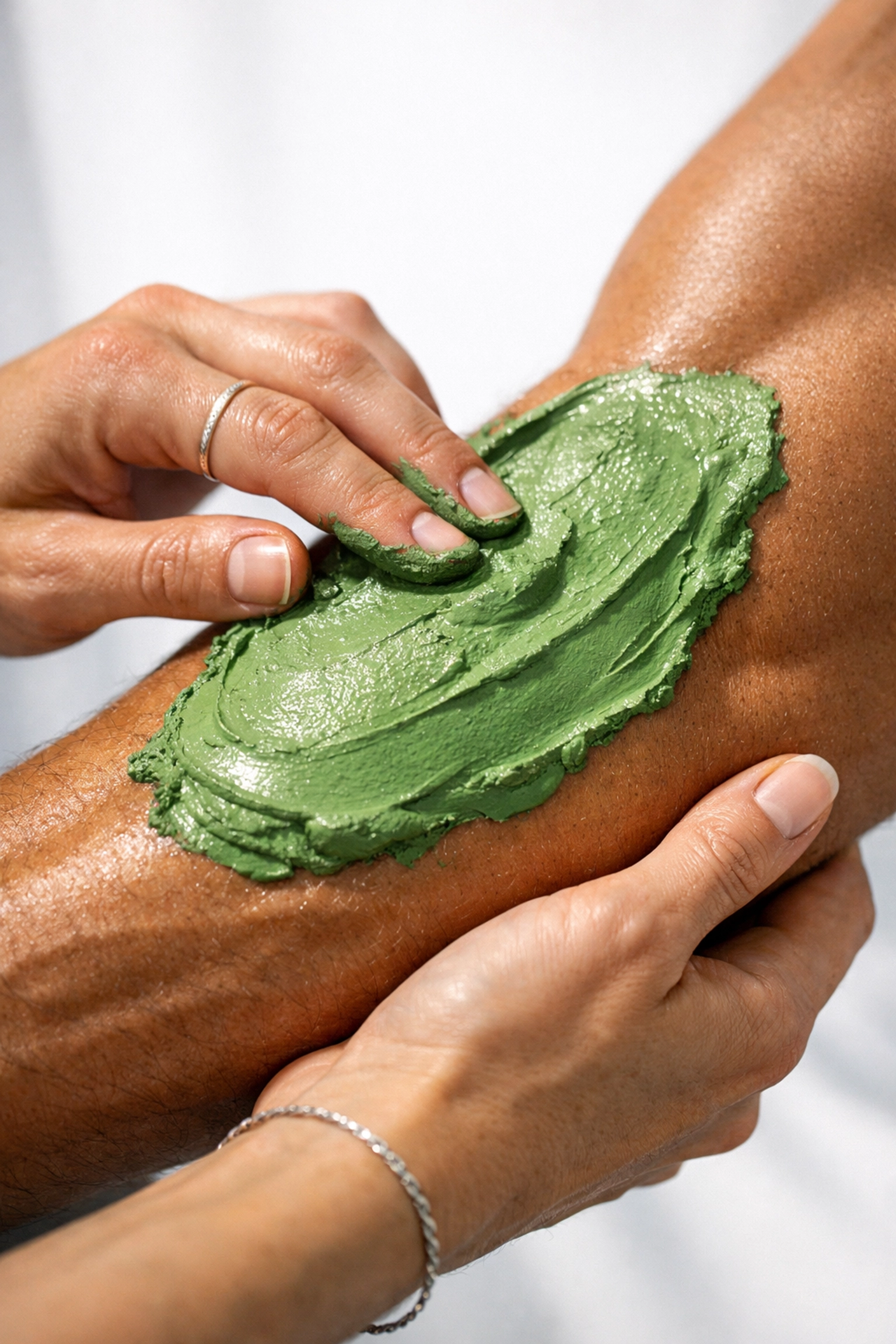 French green clay applied to athlete's forearm for natural muscle recovery