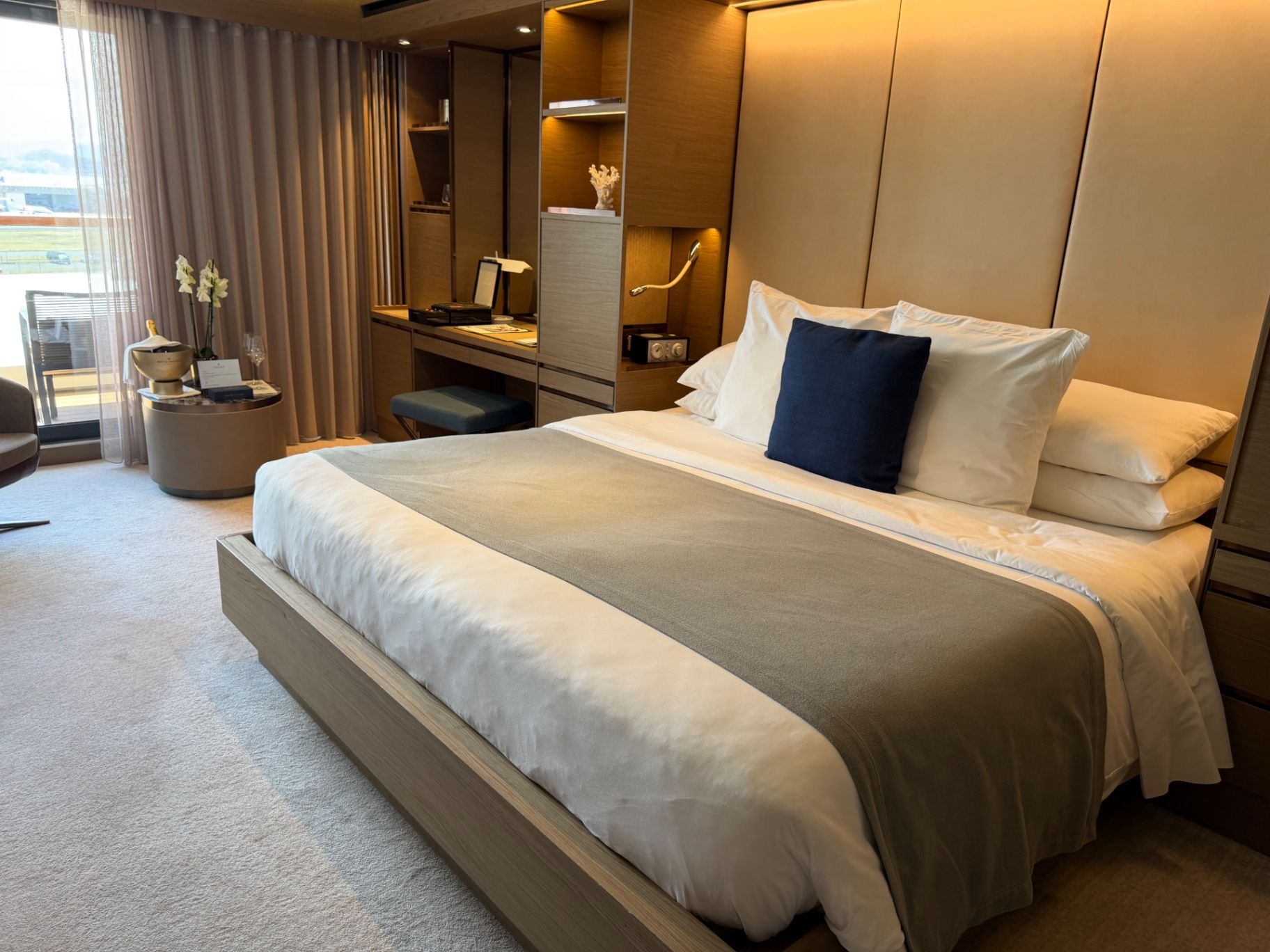 a bed with a headboard and a desk in a room