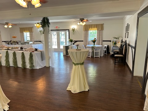 Elegant indoor reception area at The Sugarhouse featuring hardwood floors, large windows, and buffet tables arranged for service.