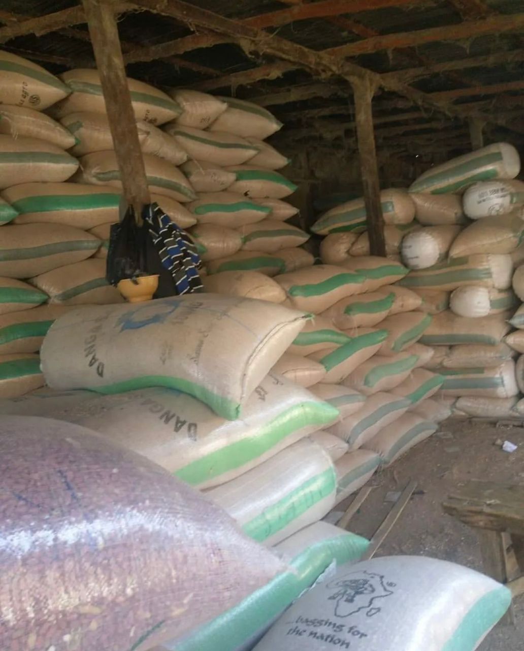 Stacked sacks of agricultural produce in a rural warehouse, organized for export by Olat Group LLC.