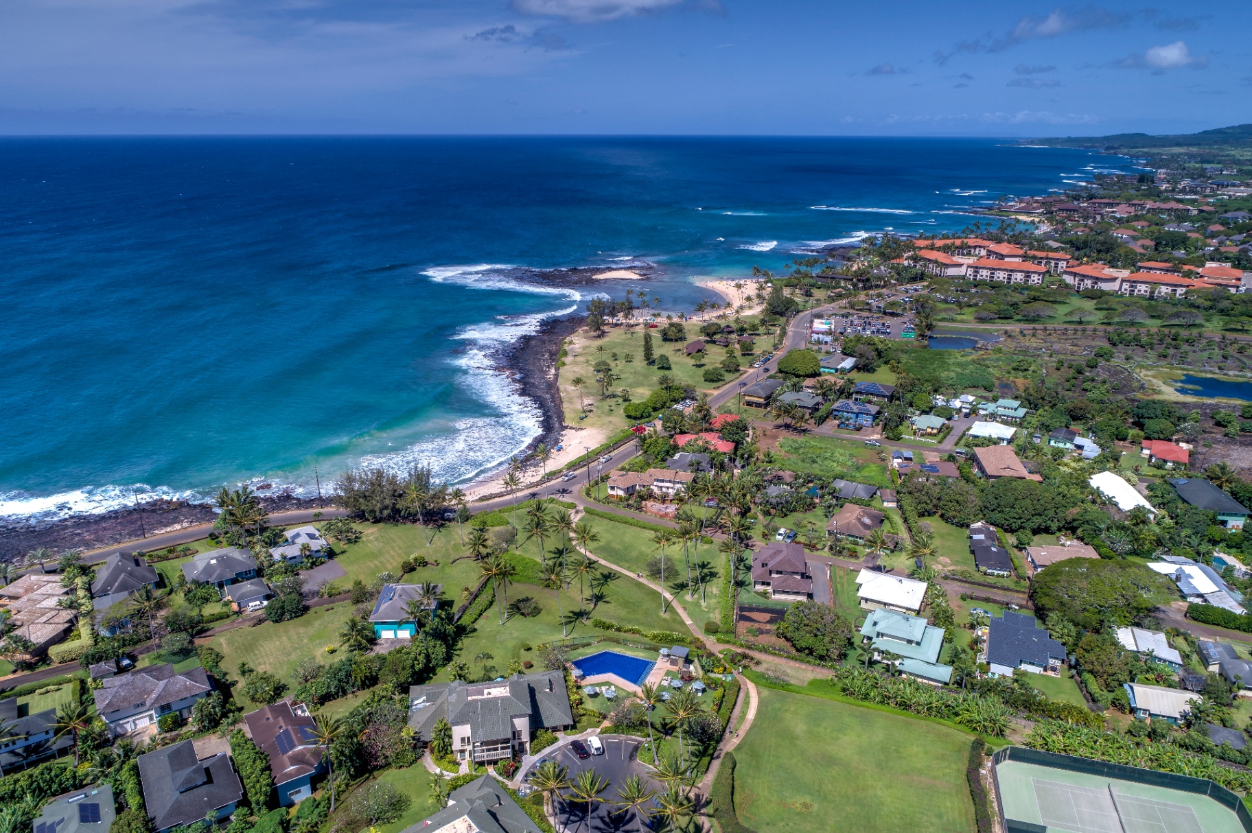 Sandy Door oceanfront vacation rentals in Kauai - hero image showing turquoise water and coastline
