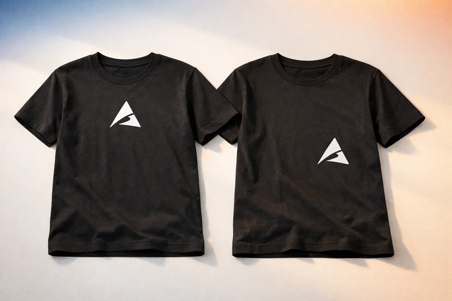 Two black custom t-shirts showing inconsistent logo placement from different print orders