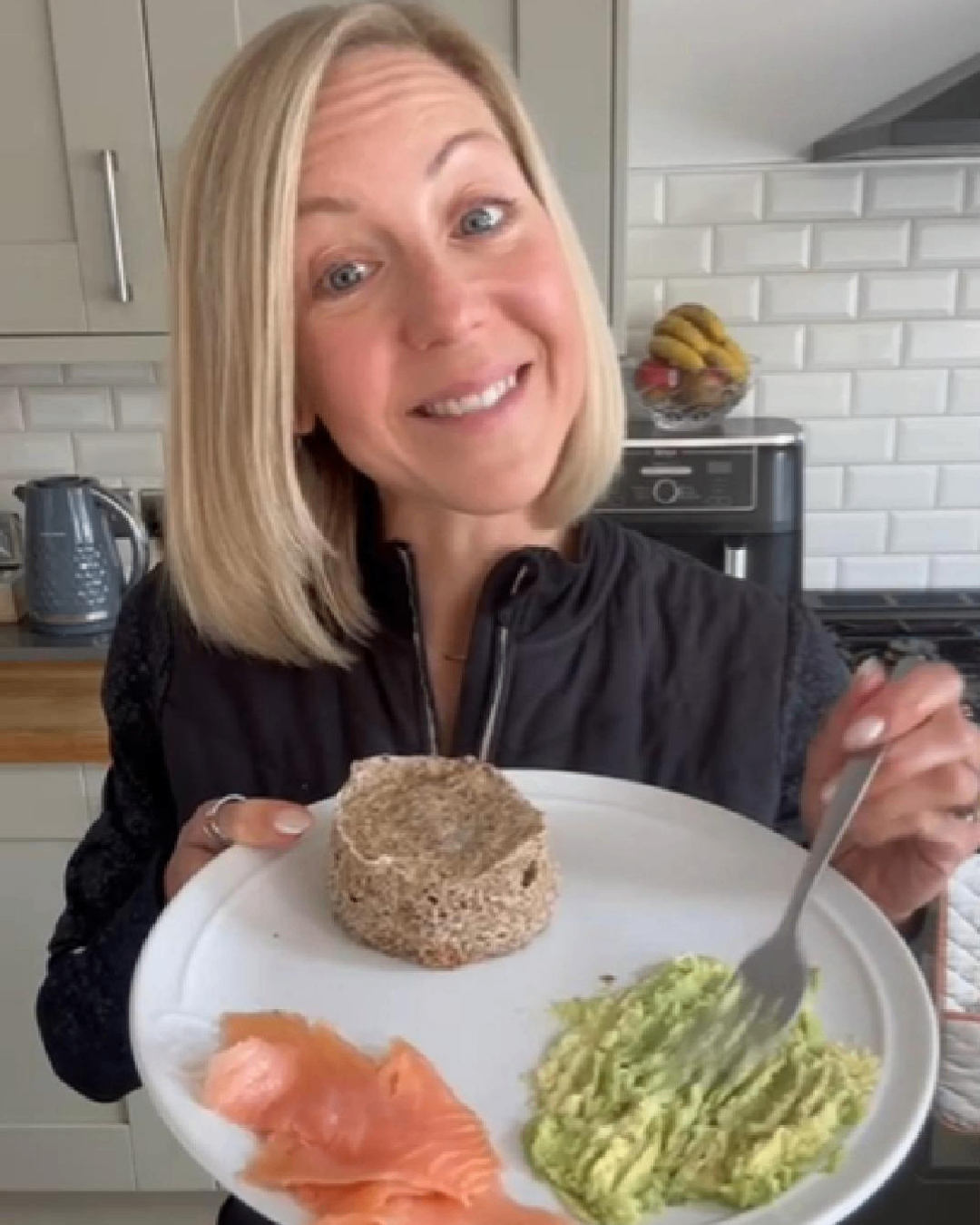 A smiling woman in a modern kitchen with a healthy meal A smiling woman in a modern kitchen with a healthy meal