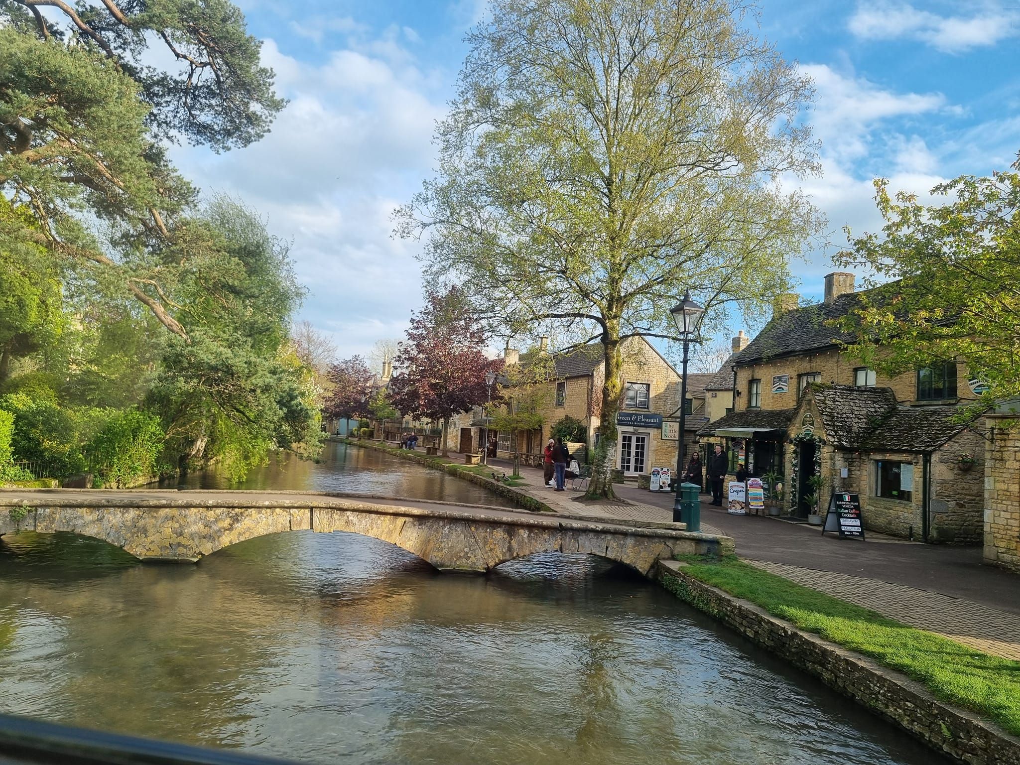A winter view of Bourton-on-the-Water with the stone footbridge and river.