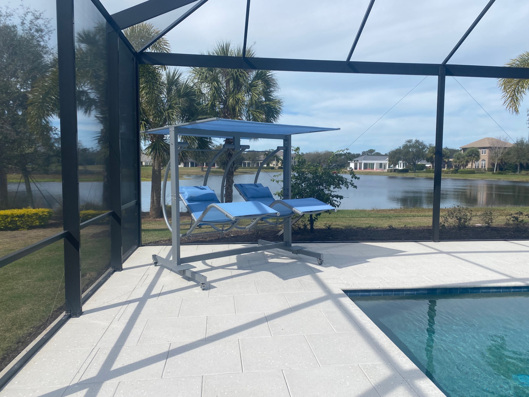 Laguna Grande luxury double zero-gravity swing on a marble patio, creating a private oasis by the pool.