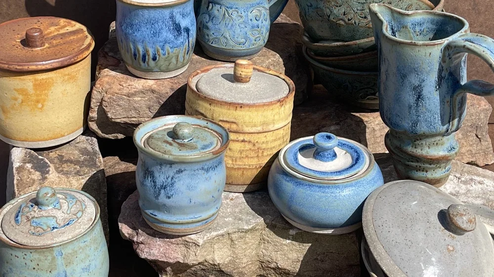 Assorted handcrafted pottery pieces on rustic rocks
