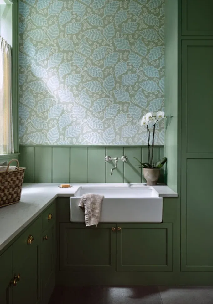 High-end utility room featuring custom cabinetry painted in refined sage green