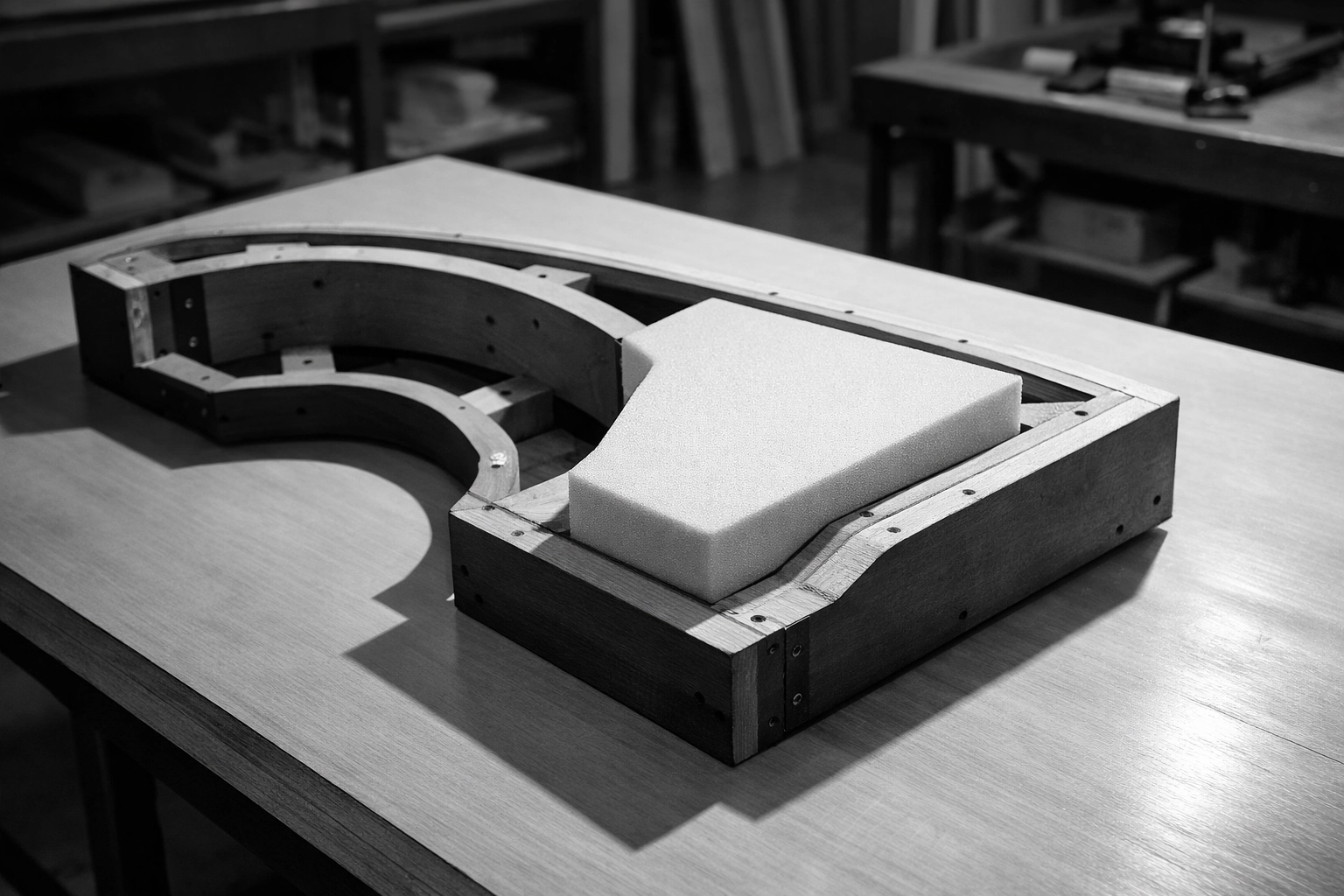 Custom cut foam being precision fitted into a unique furniture frame for expert restoration.