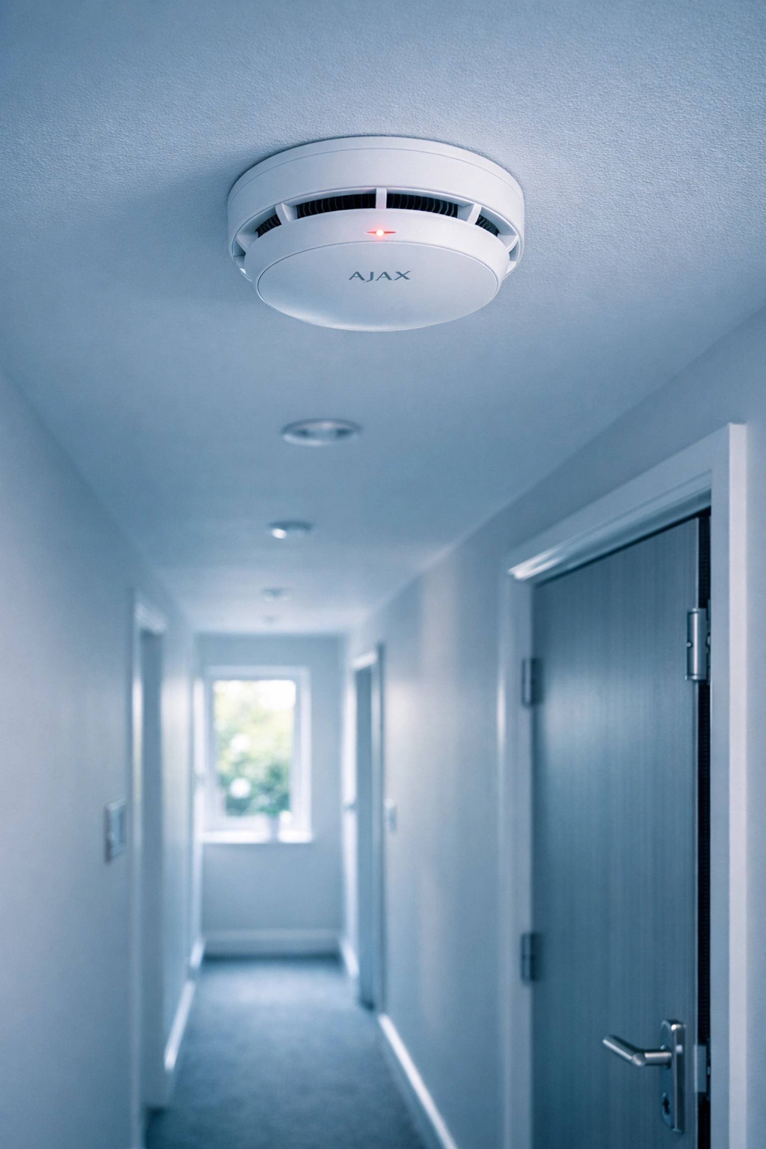 Wireless AJAX fire alarm detector installed in HMO hallway with compliant fire door