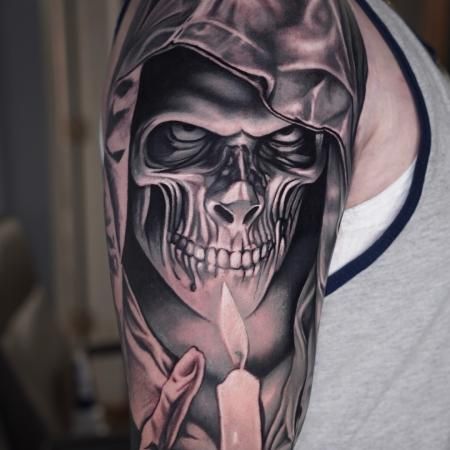 A hyper-realistic black and grey tattoo of a hooded grim reaper, demonstrating the power of deep contrast and intense facial detail.
