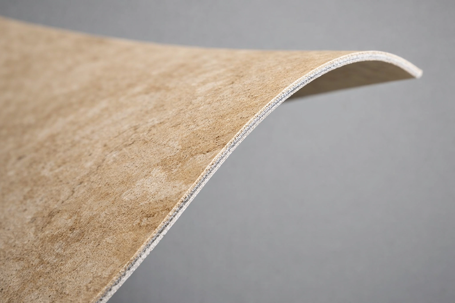 3mm thin Flexible Natural Stone™ panel in beige travertine showing material flexibility and texture.