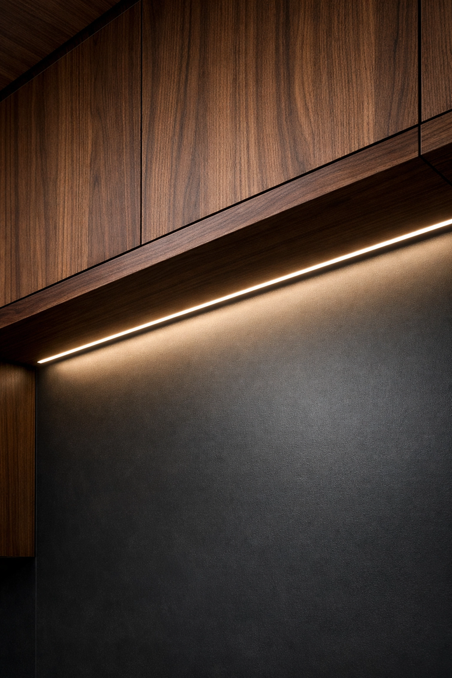 Diffused under-cabinet LED lighting installed in a modern kitchen with dark walnut cabinetry.