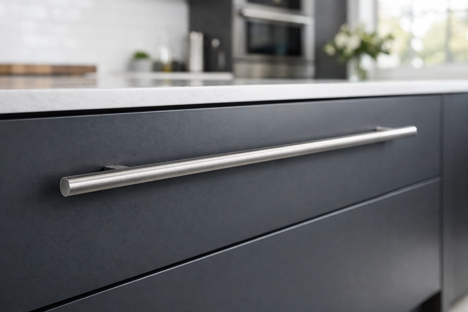 Charcoal grey drawer featuring a sleek stainless steel handle for a kitchen cabinet refacing project.