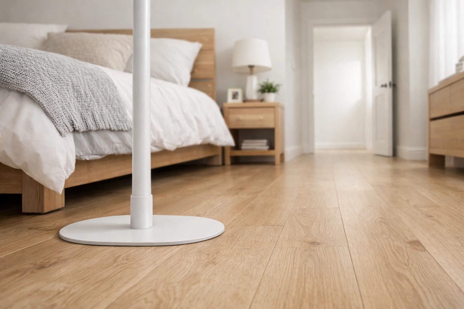 A floor-to-ceiling transfer pole with a low-profile base to prevent trip hazards in a bedroom.