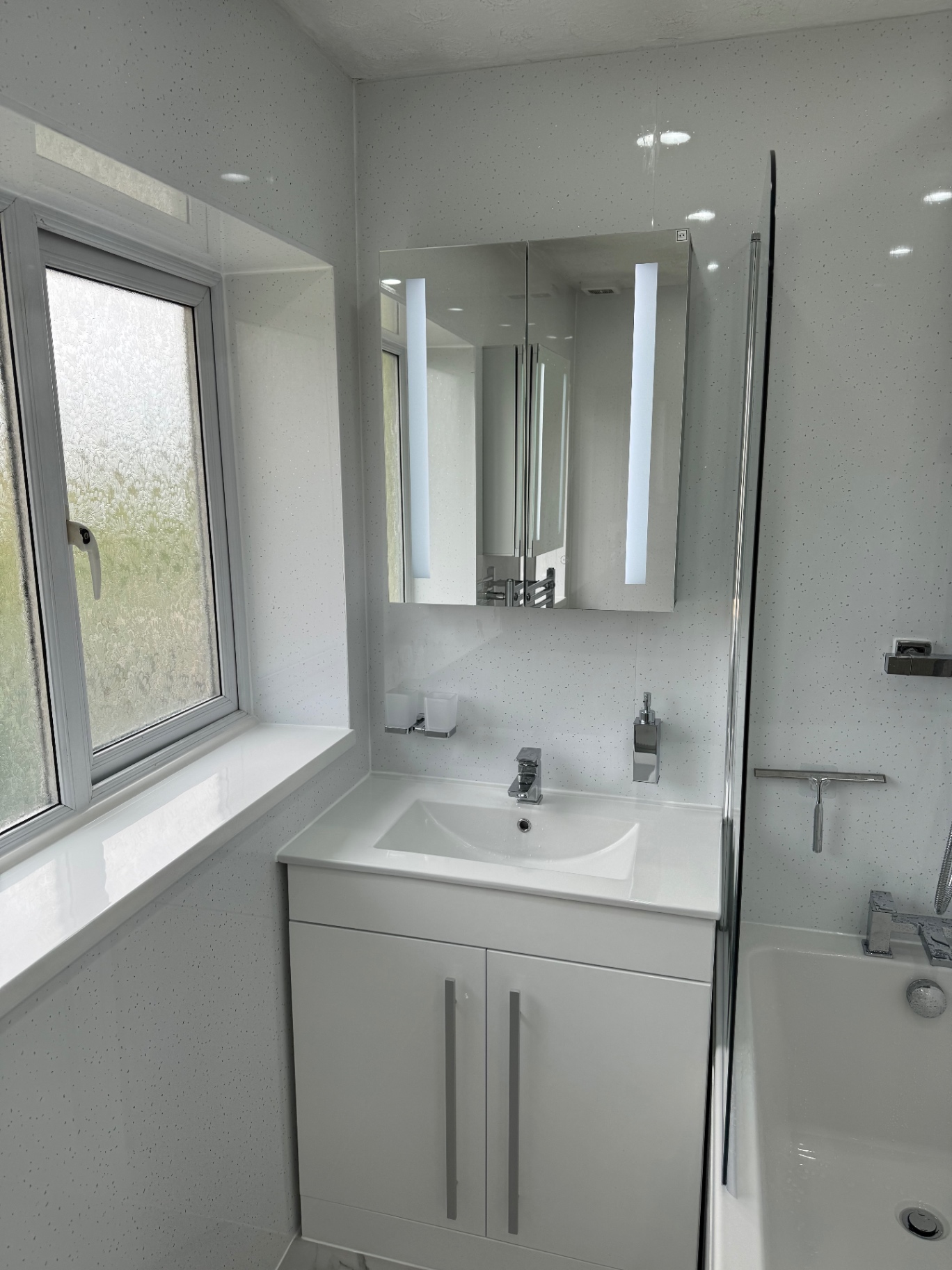 A fitted white vanity unit with integrated sink and eco-friendly water-saving fixtures